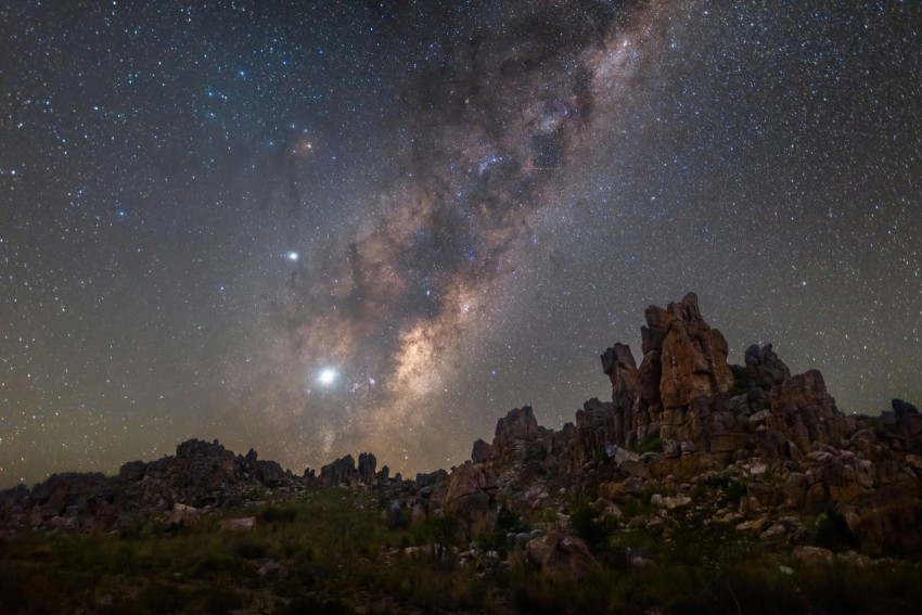 a rocky landscape with stars in the sky 8mT3al