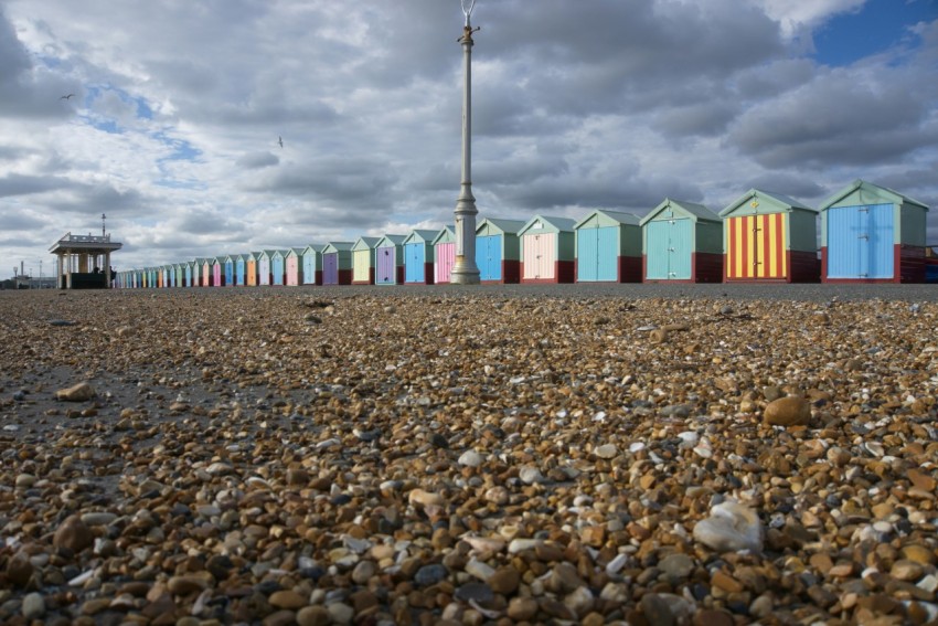 a row of colorful beach huts sitting on top of a sandy beach