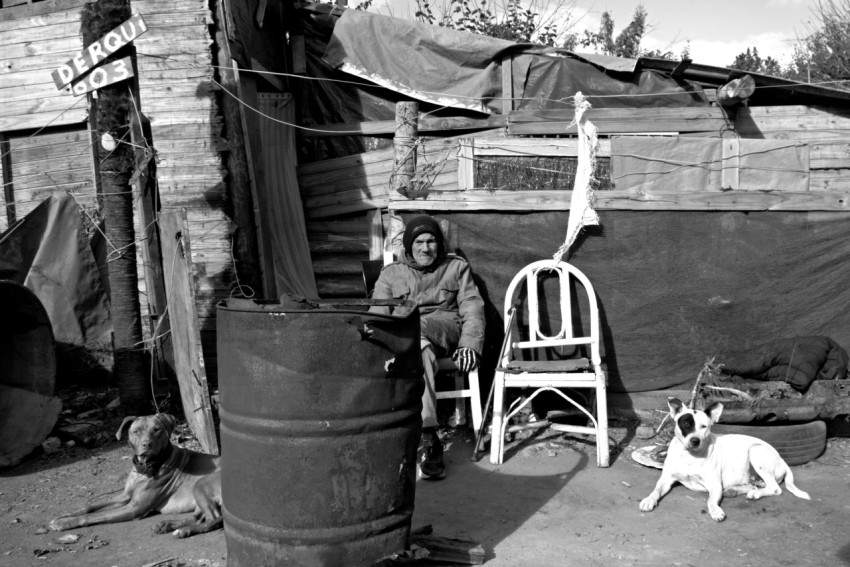 a man sitting on a chair next to a dog qgVP3h