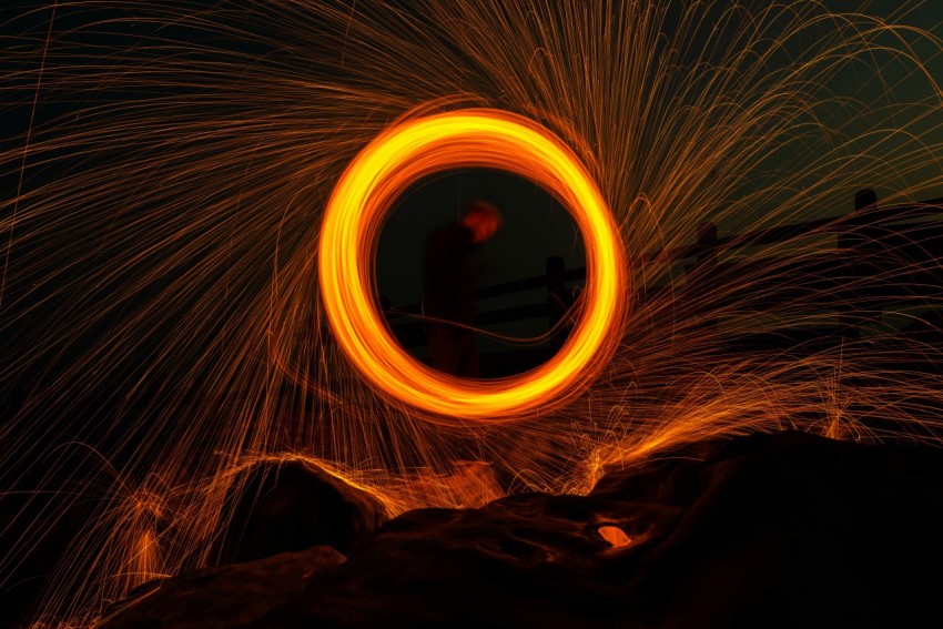 time lapse photography of person standing on brown rock