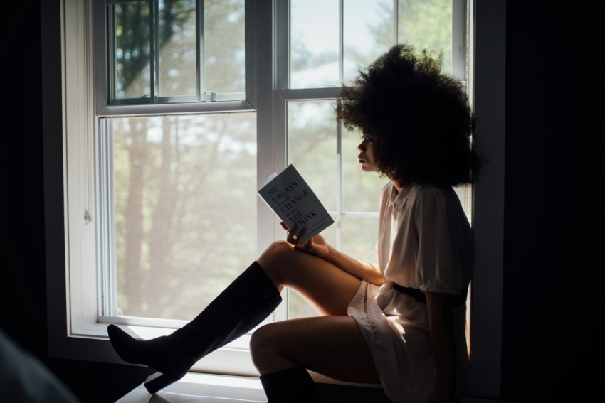 woman in white top holding book