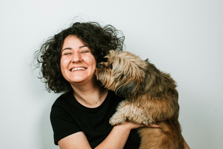 dog kissing woman in black crew neck shirt