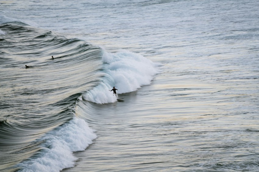 a person riding a wave on top of a surfboard