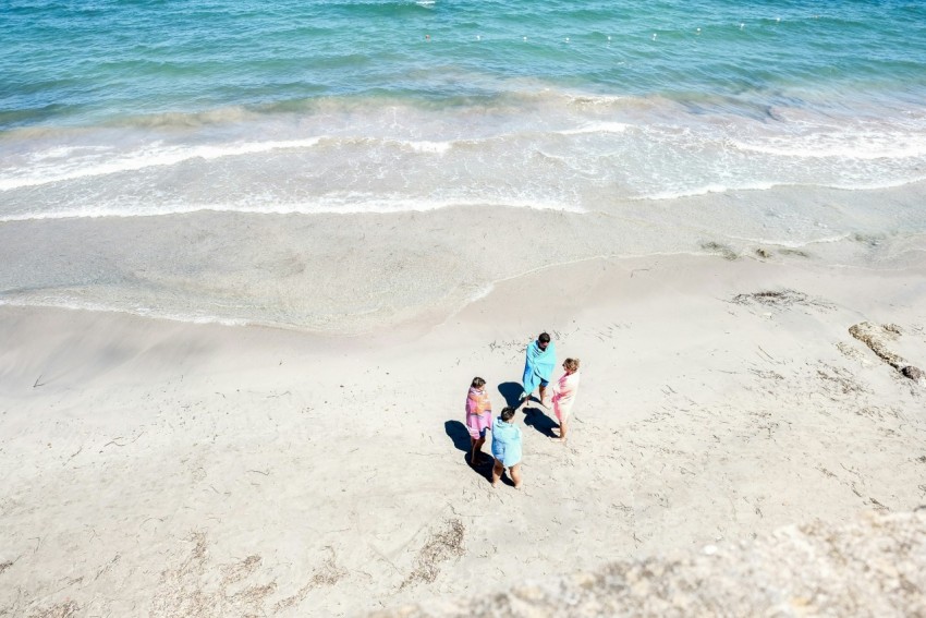 four people standing on seashore M