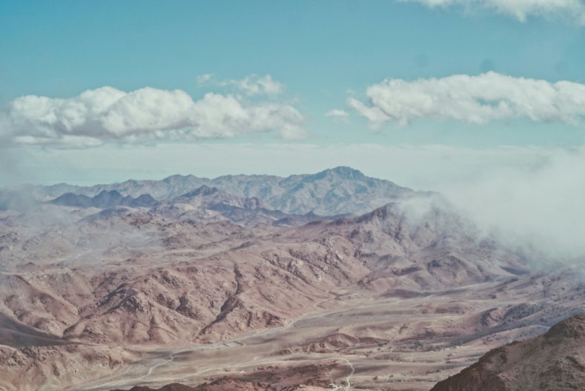 a view of a mountain range with clouds in the sky