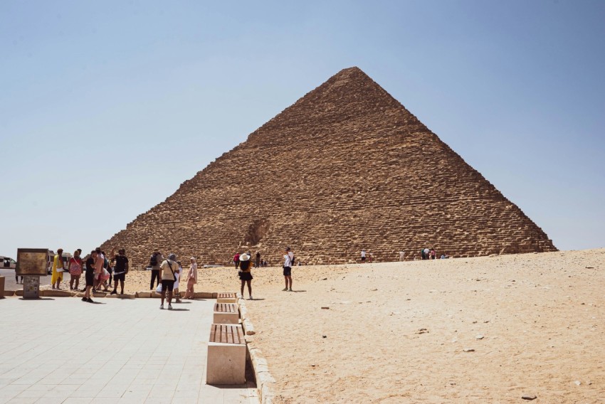 a group of people standing in front of a pyramid