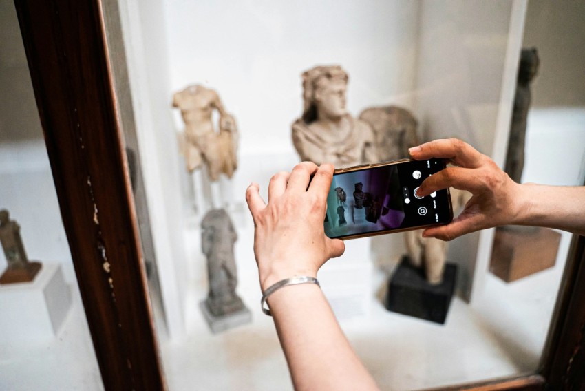 a person taking a picture of a statue in a mirror