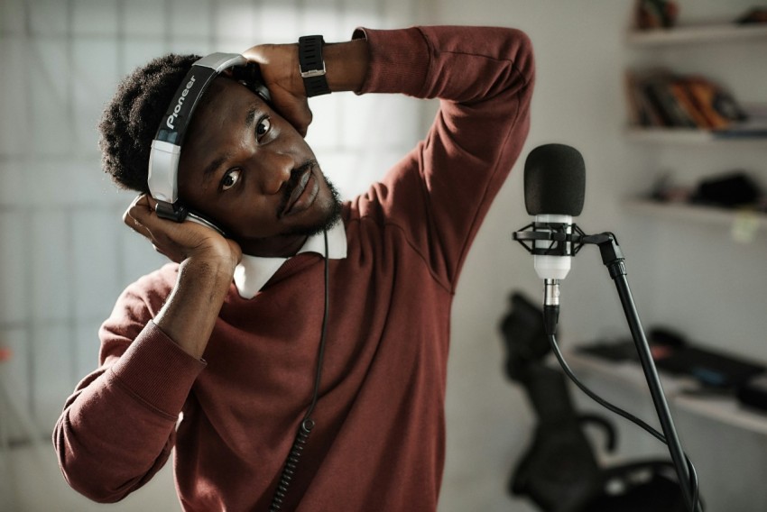 a man wearing headphones while standing in front of a microphone