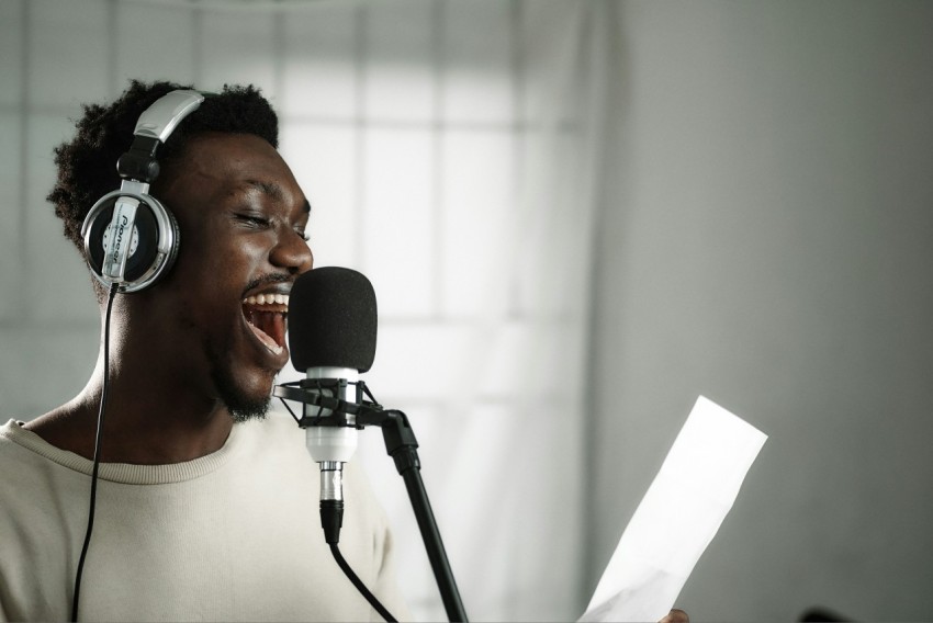 a man wearing headphones singing into a microphone n_qhPU