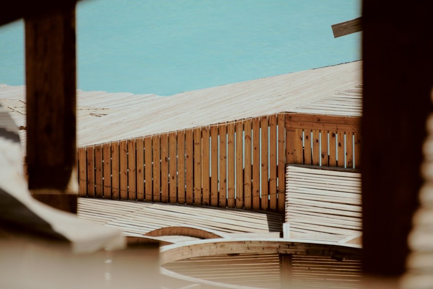 a wooden bench sitting next to a wooden fence