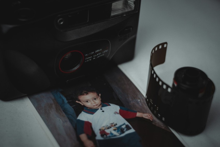 a photo of a young boy next to a camera vbu