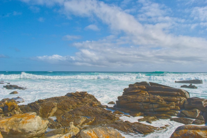 time lapse photography of ocean waves hammering rocks