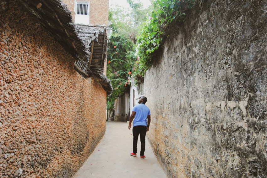 man in white dress shirt walking on pathway during daytime