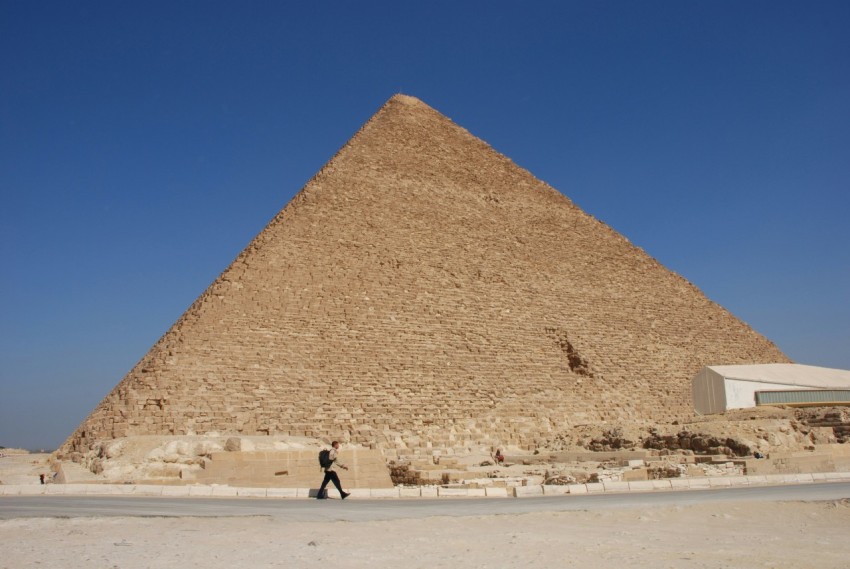 people walking on beach near pyramid during daytime