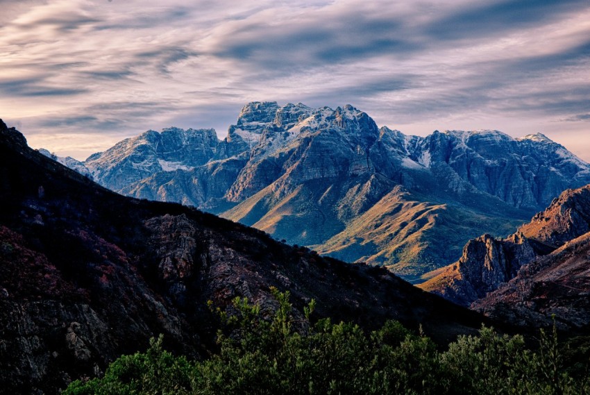 a view of a mountain range with trees in the foreground