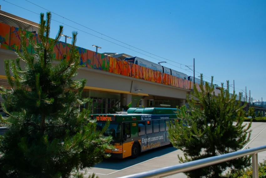 a bus driving down a street next to a bridge