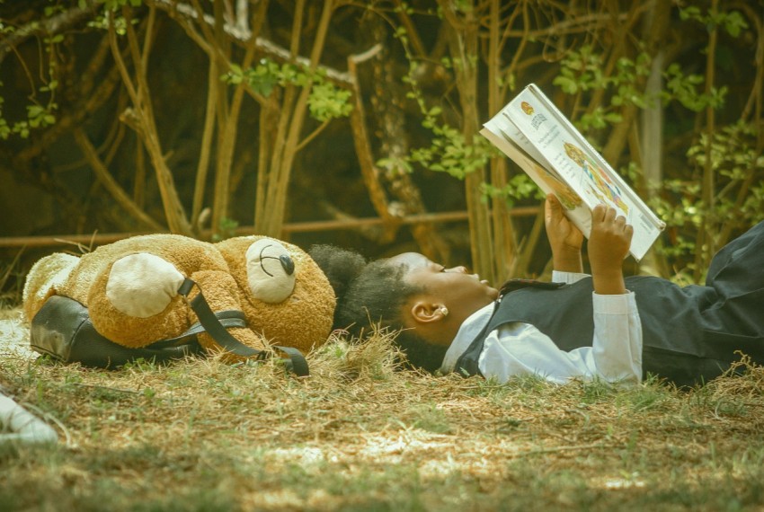 a person laying on the ground reading a book