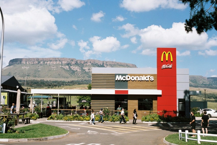 a mcdonalds restaurant with a mountain in the background