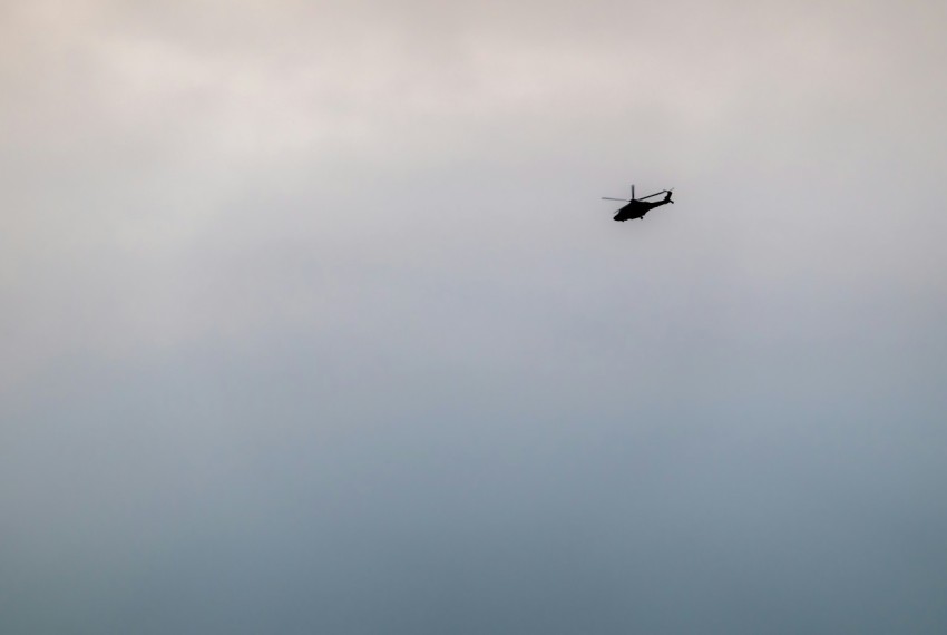 a helicopter flying through a cloudy sky