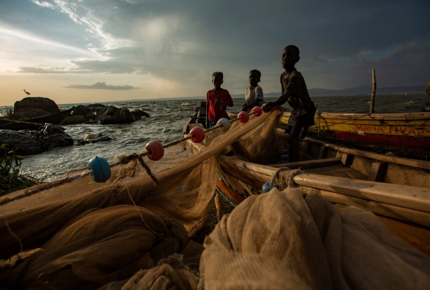 a group of people standing on top of a boat near the ocean 1lS