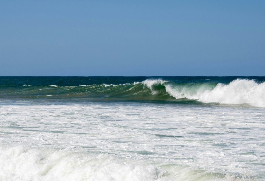 a man riding a wave on top of a surfboard lB