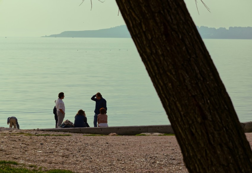 a group of people standing on top of a sandy beach