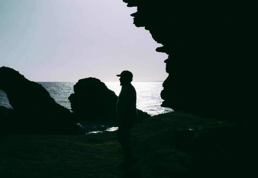 a man standing on a beach next to the ocean