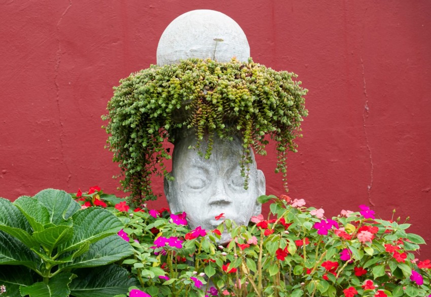 a statue of a head surrounded by flowers