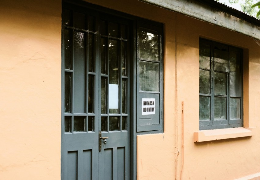 a yellow building with a sign on the door