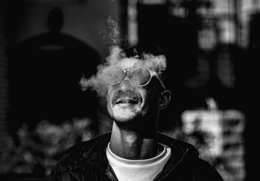 a man smoking a cigarette in a black and white photo