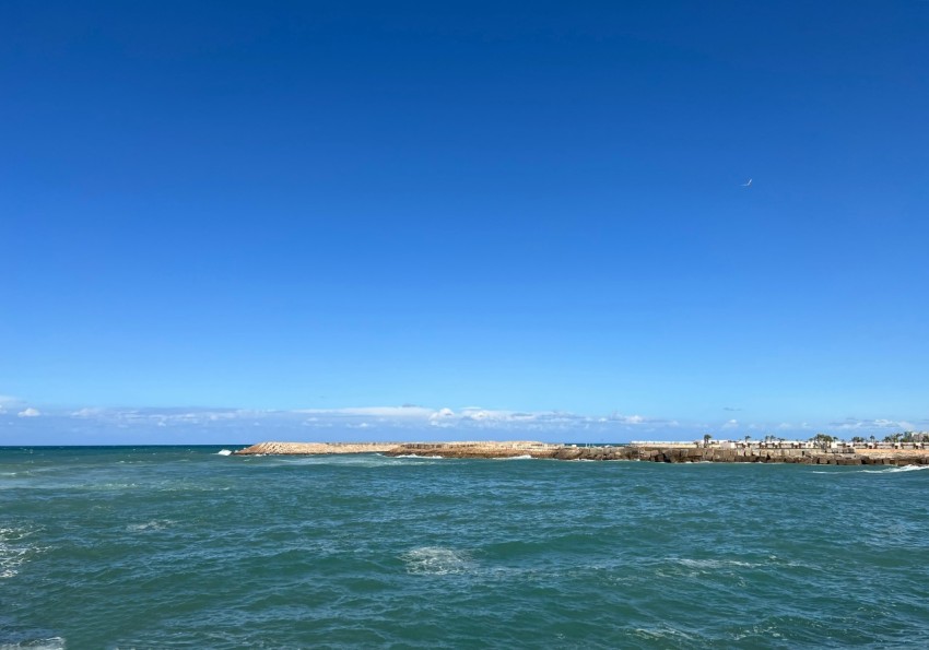 a large body of water sitting under a blue sky