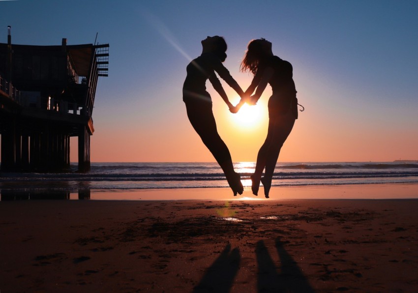 a couple of people that are standing in the sand