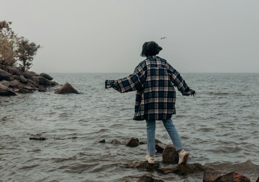 a person standing on rocks in the water