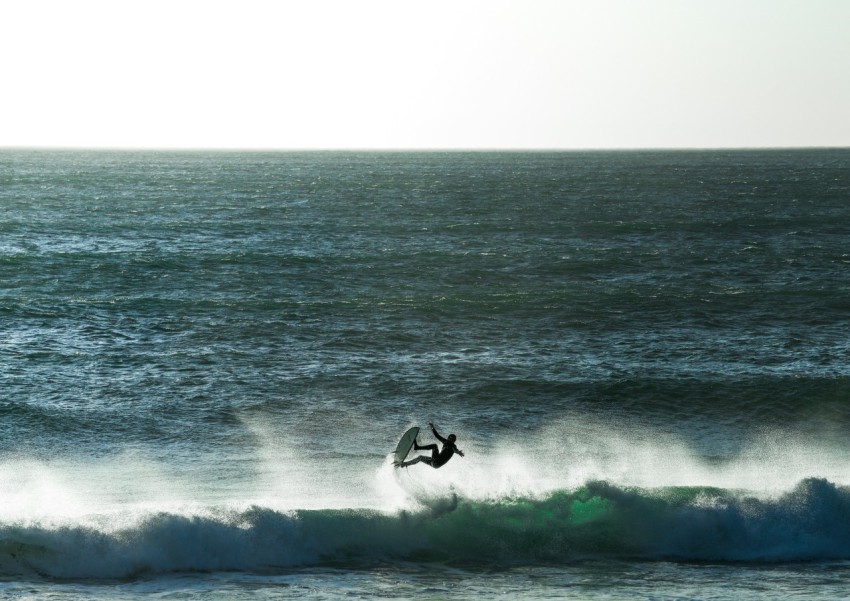 person surfing on sea waves during daytime