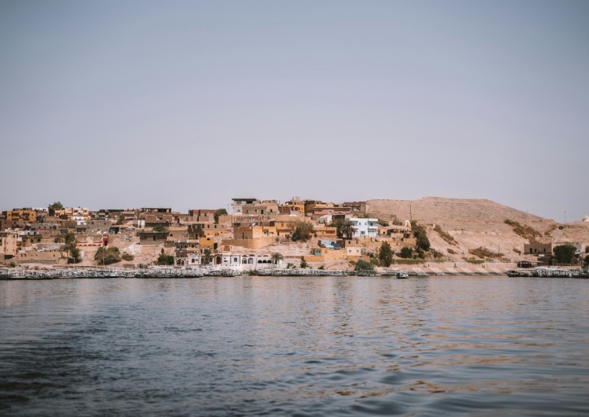 a body of water with houses on a hill in the background