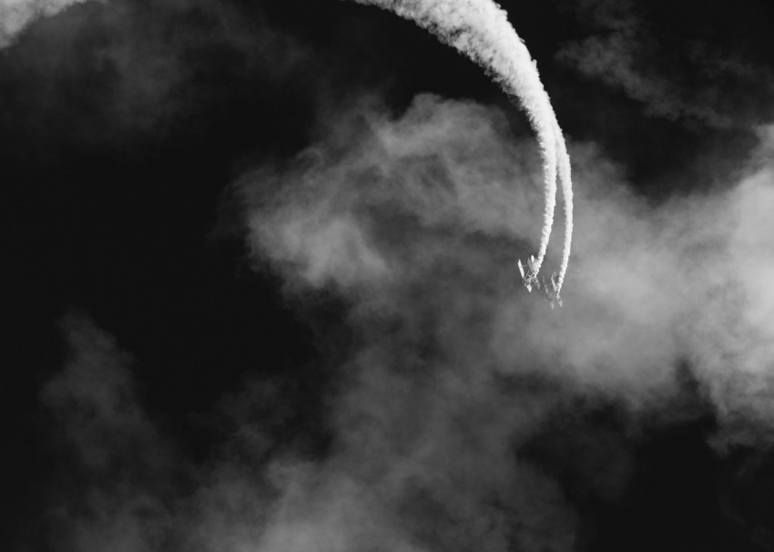 a black and white photo of a contrail in the sky