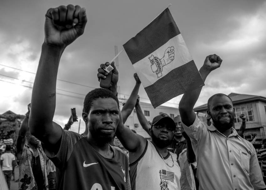 grayscale photo of man in white crew neck t shirt holding flag