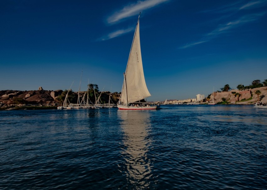 a sailboat on a body of water with a city in the background