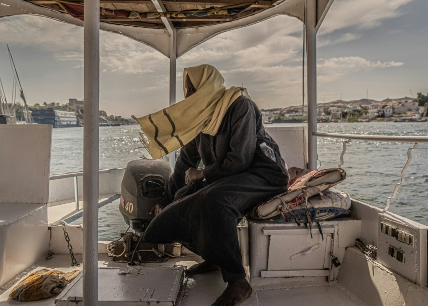 a man sitting on a boat in the water