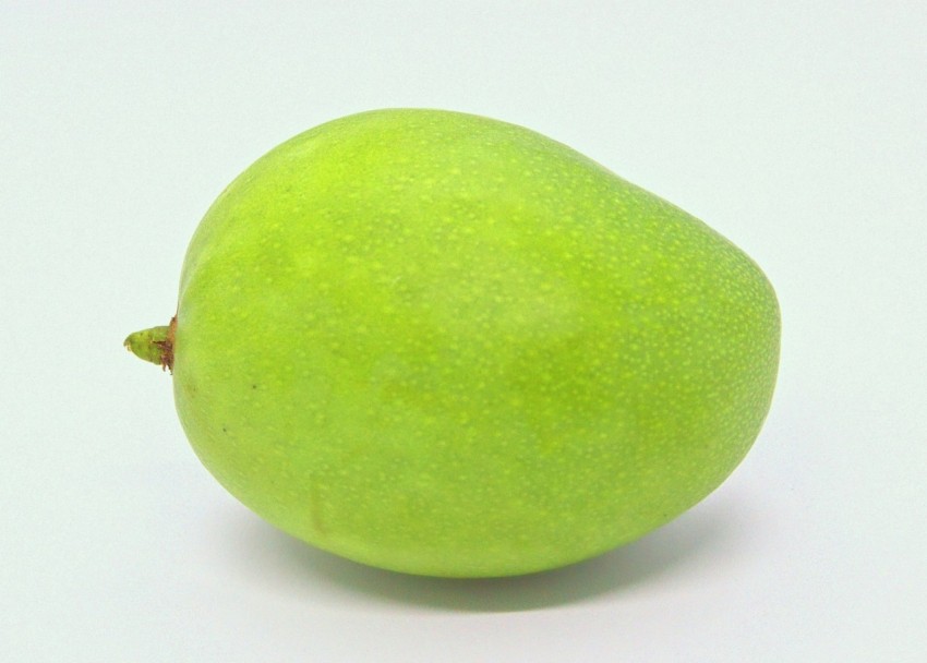 a green apple sitting on top of a white table