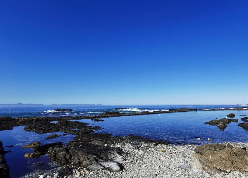 a large body of water surrounded by rocks AjMP