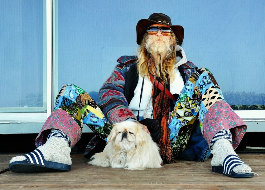 man sitting on floor beside dog during daytime