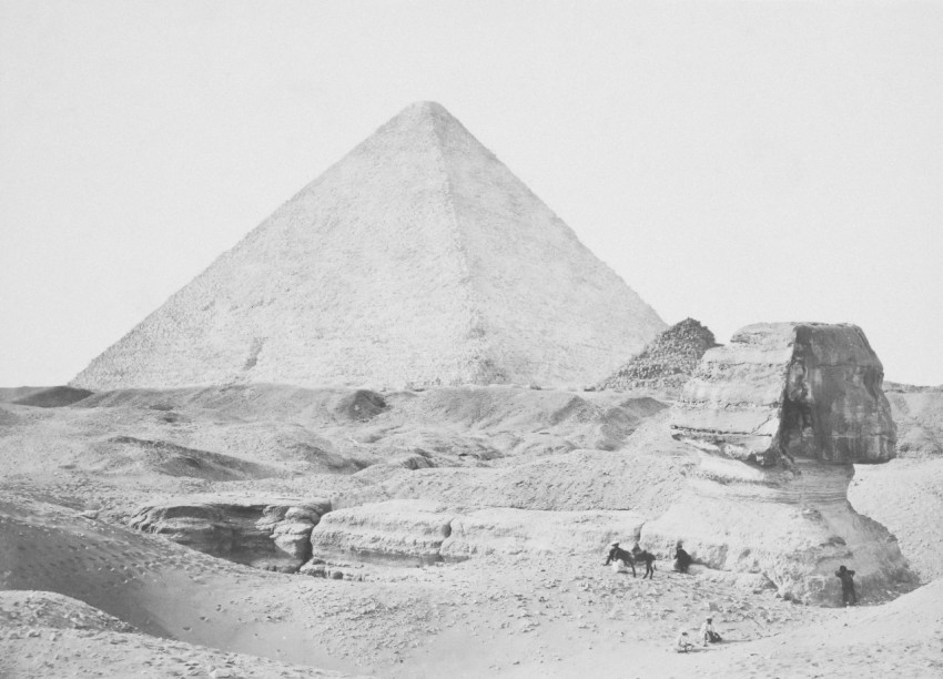 a black and white photo of a pyramid in the desert