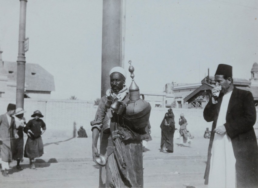 grayscale photo of man carrying jar