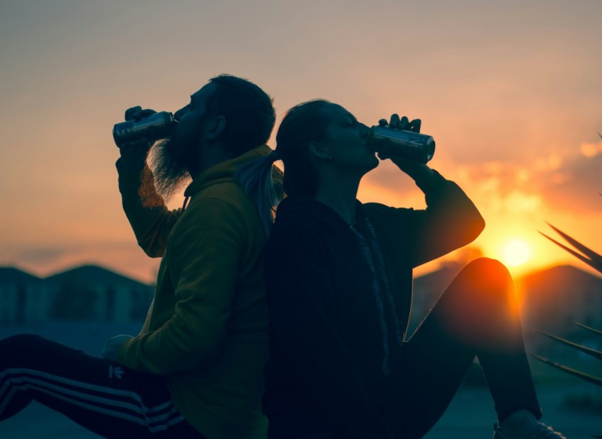 man and woman drinking tin cans