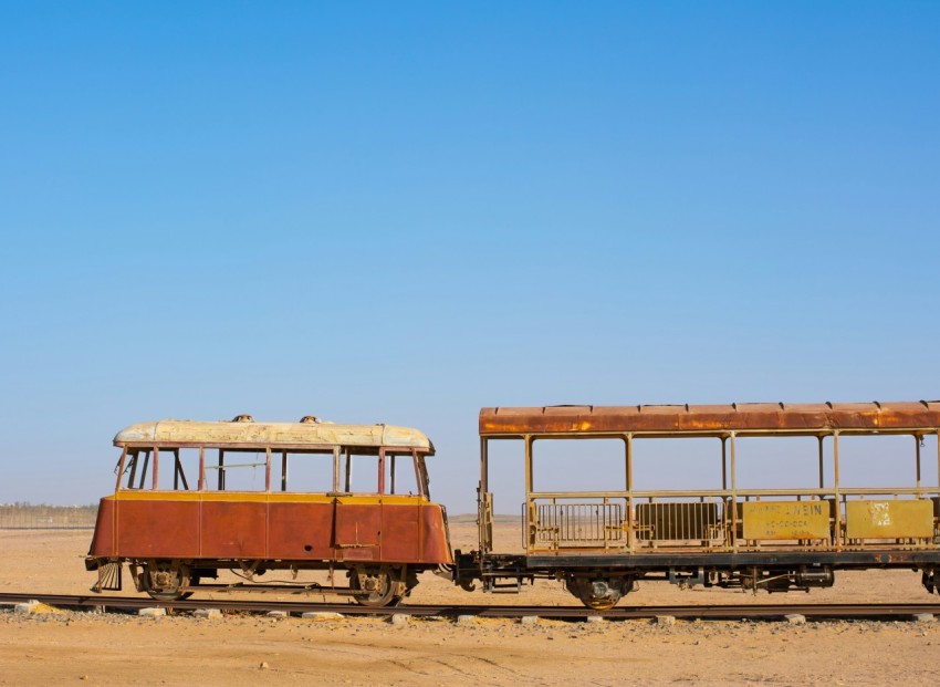 two old abandoned trolley cars in the desert