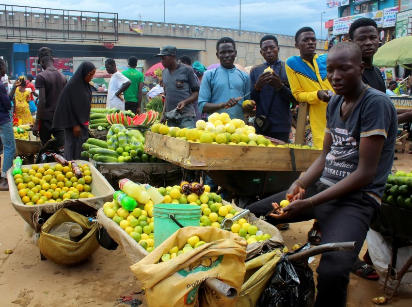 a group of people at a fruit stand