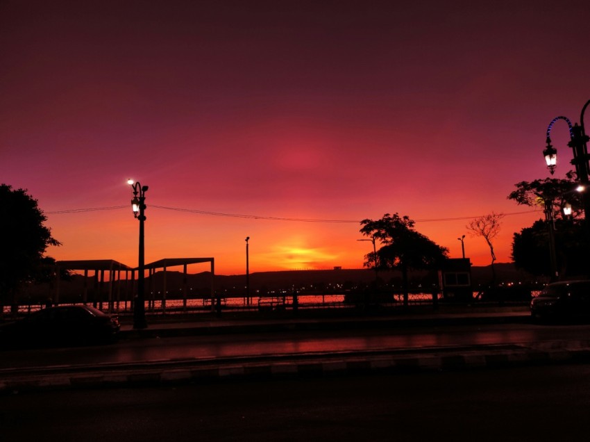 the sun is setting over a city street