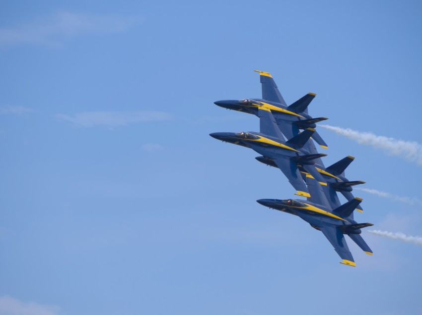 a group of fighter jets flying through a blue sky