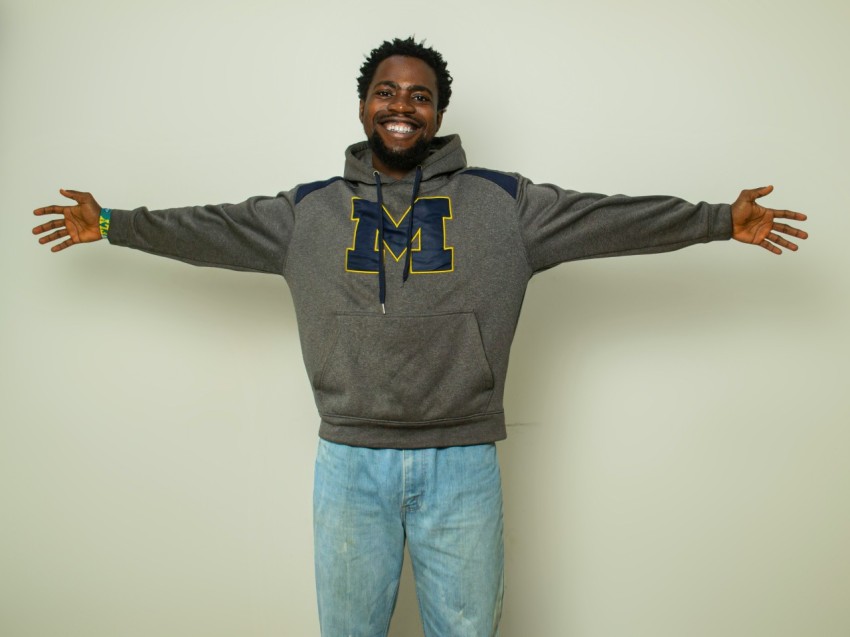 a man standing with his arms outstretched in front of a wall x